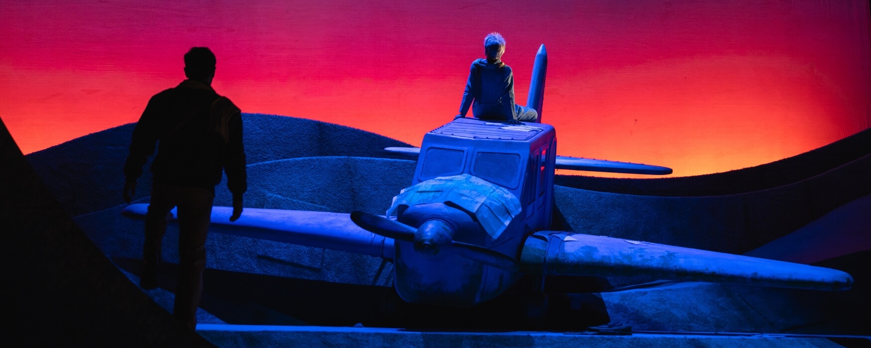 Child on a plane with a man in shadows - The Little Prince at The Dallas Opera